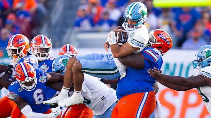 Florida Gators defensive lineman Desmond Watson (21) tackles Tulane Green Wave quarterback Ty Thompson (7) during the first half at Raymond James Stadium in Tampa, FL on Friday, December 20, 2024 in the 2024 Union Home Mortgage Gasparilla Bowl. [Doug Engle/Gainesville Sun]