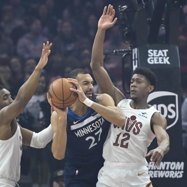 Donovan Mitchell (45) and forward De'Andre Hunter (12) defend Minnesota Timberwolves center Rudy Gobert (27)