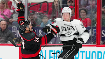 Feb 1, 2025; Raleigh, North Carolina, USA;  Los Angeles Kings defenseman Brandt Clarke (92) checks Carolina Hurricanes center Seth Jarvis (24) during the third period at Lenovo Center. Mandatory Credit: James Guillory-Imagn Images