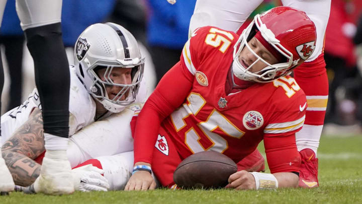 Dec 25, 2023; Kansas City, Missouri, USA; Kansas City Chiefs quarterback Patrick Mahomes (15) reacts after being sacked by Las Vegas Raiders defensive end Maxx Crosby (98) during the game at GEHA Field at Arrowhead Stadium. Mandatory Credit: Denny Medley-USA TODAY Sports