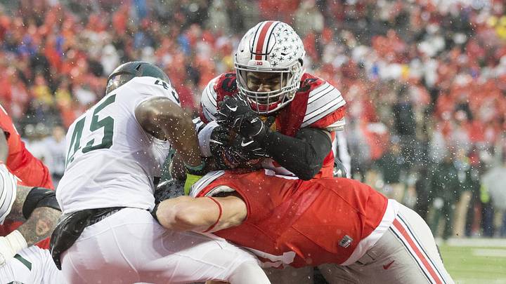 Nov 15, 2015; Columbus, OH, USA; Ohio State Buckeyes tight end Nick Vannett (81) blocks Michigan State Spartans linebacker Darien Harris (45) as Ohio State Buckeyes running back Ezekiel Elliott (15) scores over the top in the first half of their game at Value City Arena. Mandatory Credit: Greg Bartram-Imagn Images