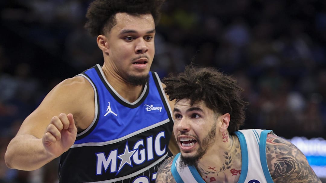 Charlotte Hornets guard LaMelo Ball drives the ball past Orlando Magic forward Noah Penda.