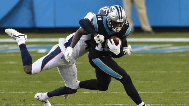 Dec 13, 2020; Charlotte, NC;  Carolina Panthers wide receiver Curtis Samuel (10) is tackled by Denver Broncos cornerback De'Vante Bausby in the fourth quarter at Bank of America Stadium.