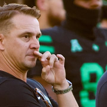 North Texas Mean Green head coach Eric Morris watches his team warm up prior to a game against the South Florida Bulls at DATCU Stadium.