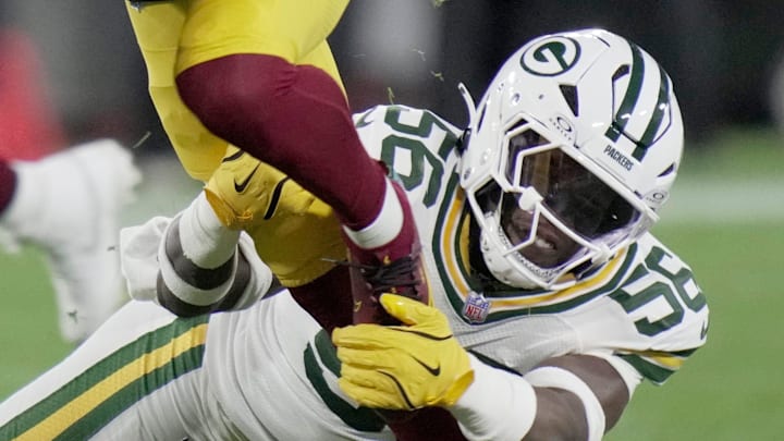 Green Bay Packers linebacker Edgerrin Cooper (56) tackles Washington Commanders quarterback Jayden Daniels.