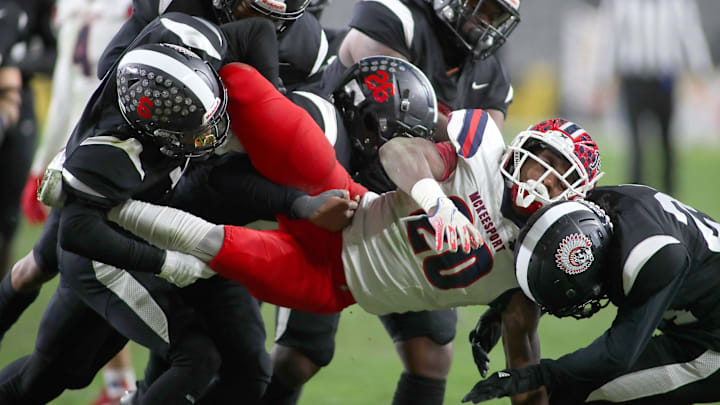McKeesport's Kemon Spell (20) gets taken to the ground by multiple Aliquippa defenders during the second half of the WPIAL 4A Championship game Friday evening at Acrisure Stadium in Pittsburgh, PA.