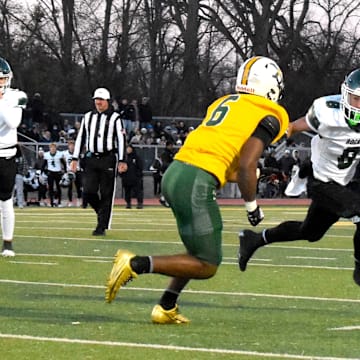 Trinity High School running back Ashton Taylor tries to beat St. Xavier's  Marlon Harbin III to the outside Friday, Nov. 28, 2025, in a 6A state semifinal game between the programs.