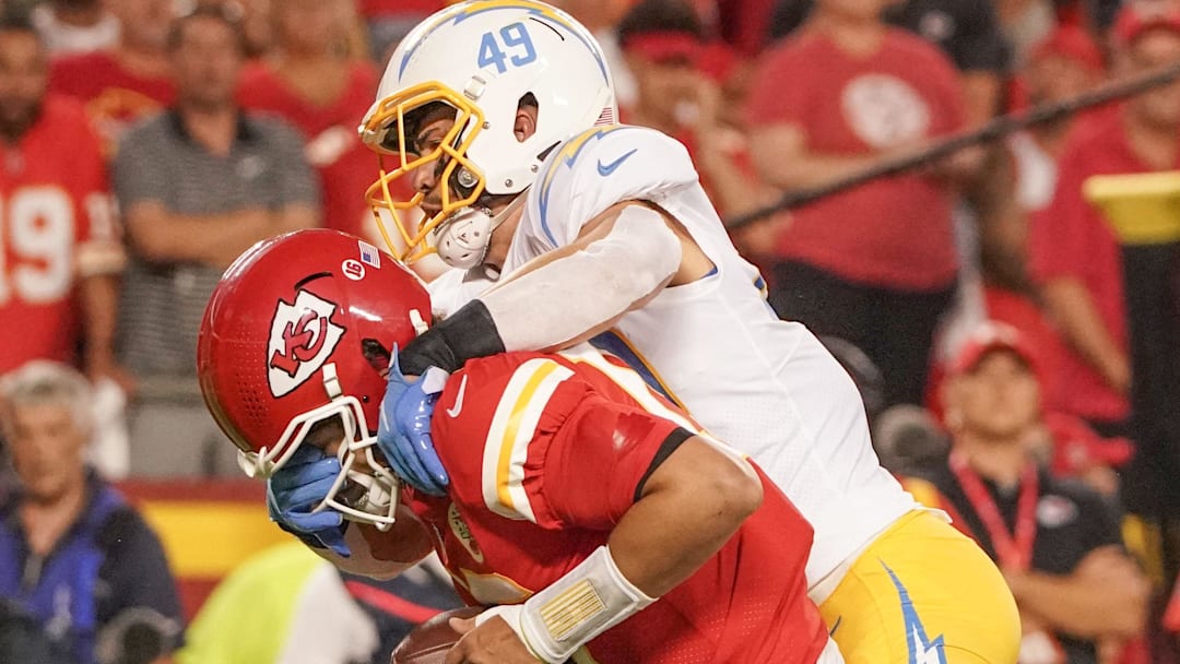 Sep 15, 2022; Kansas City, Missouri, USA; Los Angeles Chargers linebacker Drue Tranquill (49) attempts the tackle on Kansas City Chiefs quarterback Patrick Mahomes (15) during the game at GEHA Field at Arrowhead Stadium. Mandatory Credit: Denny Medley-Imagn Images