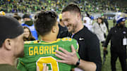 Nov 9, 2024; Eugene, Oregon, USA; Oregon Ducks head coach Dan Lanning celebrates with quarterback Dillon Gabriel (8) after beating the Maryland Terrapins at Autzen Stadium. Mandatory Credit: Troy Wayrynen-Imagn Images