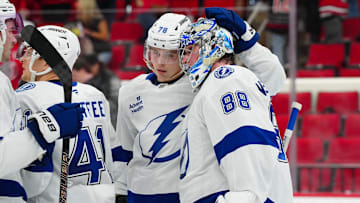 Oct 11, 2024; Raleigh, North Carolina, USA;  Tampa Bay Lightning goaltender Andrei Vasilevskiy (88) and defenseman Emil Lilleberg (78) celebrate their victory against the Carolina Hurricanes at PNC Arena. Mandatory Credit: James Guillory-Imagn Images