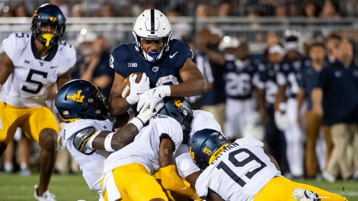 Penn State running back Nicholas Singleton is tackled while carrying the ball against West Virginia at Beaver Stadium in 2023. 