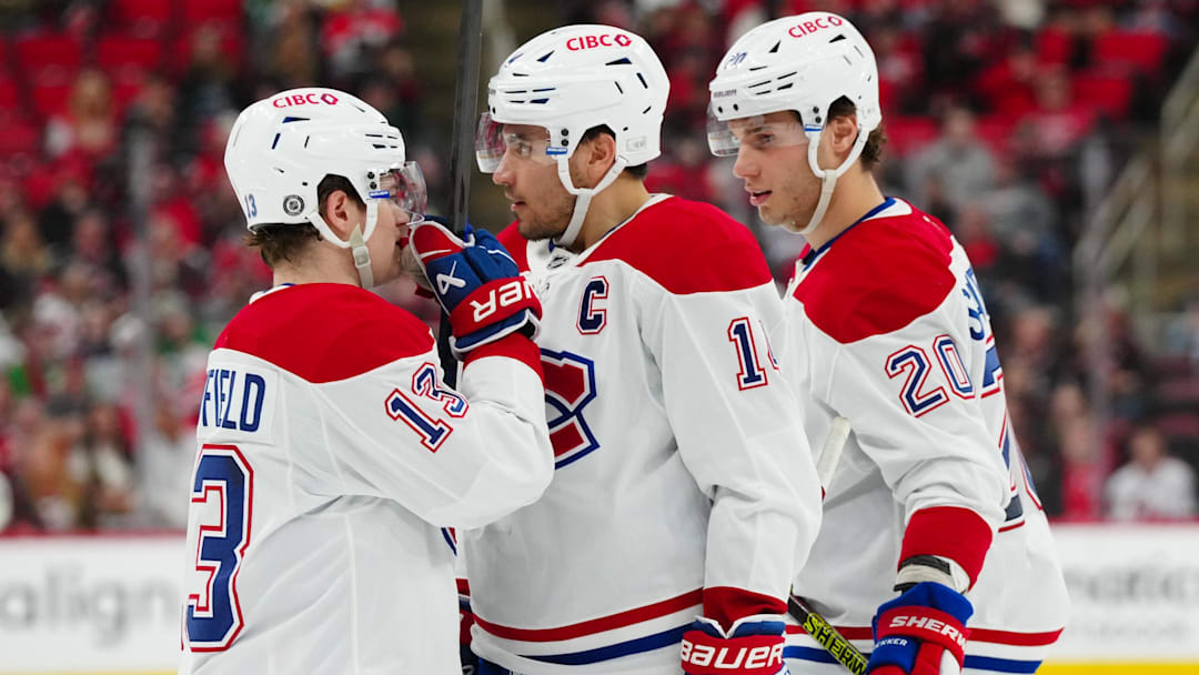 Mar 28, 2025; Raleigh, North Carolina, USA;  Montreal Canadiens right wing Cole Caufield (13) center Nick Suzuki (14) and left wing Juraj Slafkovský (20) talk against the Carolina Hurricanes during the second period at Lenovo Center. Mandatory Credit: James Guillory-Imagn Images