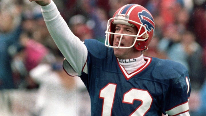 Buffalo Bills quarterback Jim Kelly pointing to the sky after throwing a touchdown pass during an NFL game