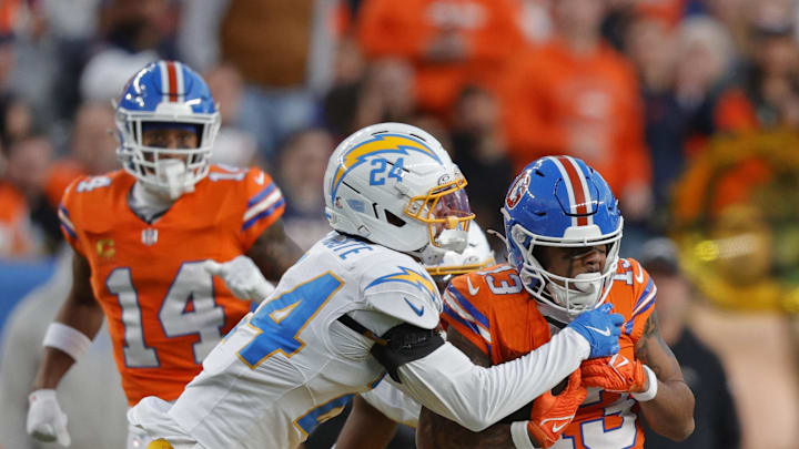 Jan 4, 2026; Denver, Colorado, USA; Los Angeles Chargers cornerback Benjamin St-Juste (24) tackles Denver Broncos wide receiver Pat Bryant (13) during the second half at Empower Field at Mile High. Mandatory Credit: Isaiah J. Downing-Imagn Images