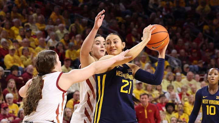 Jan 11, 2026; Ames, Iowa, USA; West Virginia Mountaineers forward Riley Makalusky (21) is defended by Iowa State Cyclones guard Reese Beaty (1) and Iowa State Cyclones center Lilly Taulelei (9) during the second half at James H. Hilton Coliseum. Mandatory Credit: Reese Strickland-Imagn Images