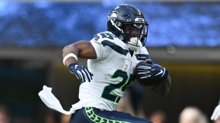 Aug 10, 2024; Inglewood, California, USA; Seattle Seahawks running back Kenny McIntosh (25) runs the ball against Los Angeles Chargers safety AJ Finley (24) during the first quarter at SoFi Stadium. Mandatory Credit: Jonathan Hui-USA TODAY Sports