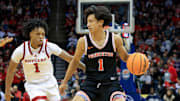 Dec 21, 2024; Newark, New Jersey, USA; Princeton Tigers guard Xaivian Lee (1) looks to pass while being defended by Rutgers Scarlet Knights guard Jamichael Davis (1) and center Emmanuel Ogbole (21) during the second half at Prudential Center. Mandatory Credit: Tom Horak-Imagn Images