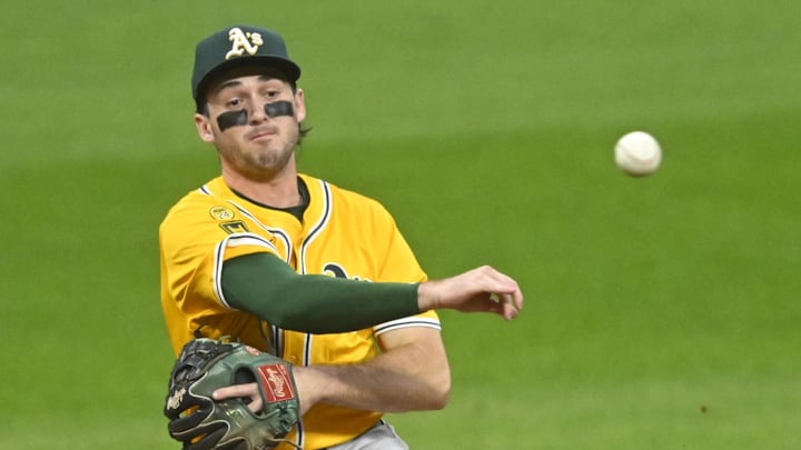 Athletics shortstop Jacob Wilson throws to first base to attempt an out.