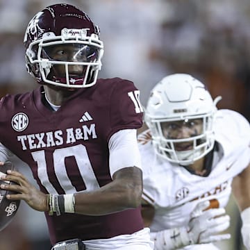 Nov 30, 2024; College Station, Texas, USA; Texas A&M Aggies quarterback Marcel Reed (10) looks for an open receiver as Texas Longhorns linebacker Trey Moore (8) defends during the fourth quarter at Kyle Field. Mandatory Credit: Troy Taormina-Imagn Images