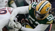 Chicago Bears quarterback Caleb Williams (18) evades a sack by Green Bay Packers defensive end Arron Mosby.