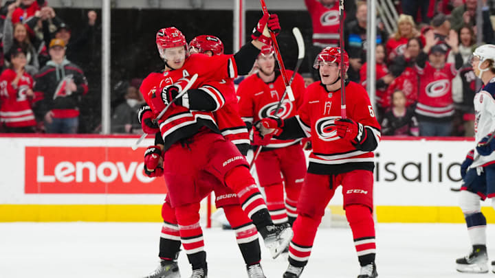 Jan 23, 2025; Raleigh, North Carolina, USA;  Carolina Hurricanes center Sebastian Aho (20) celebrates his goal with defenseman Dmitry Orlov (7) and  defenseman Jalen Chatfield (5) and right wing Jackson Blake (53) against the Columbus Blue Jackets during the second period at Lenovo Center. Mandatory Credit: James Guillory-Imagn Images