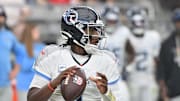 Oct 5, 2025; Glendale, Arizona, USA; Tennessee Titans quarterback Cam Ward (1) looks to throw against the Arizona Cardinals during the fourth quarter at State Farm Stadium. Mandatory Credit: Matt Kartozian-Imagn Images