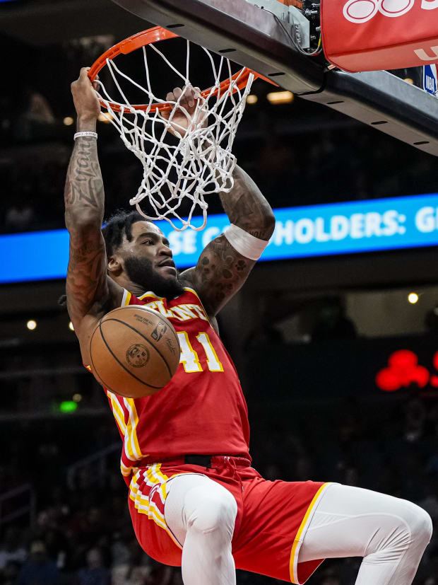 Basketball player dunks the basketball.