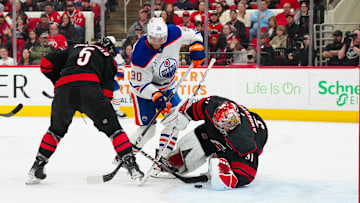 Mar 1, 2025; Raleigh, North Carolina, USA;  Carolina Hurricanes goaltender Frederik Andersen (31) and defenseman Jalen Chatfield (5) stop the scoring chance by Edmonton Oilers right wing Corey Perry (90) during the second period at Lenovo Center. Mandatory Credit: James Guillory-Imagn Images