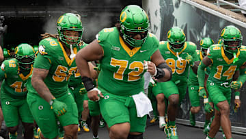Oregon’s Iapani Laloulu, center, leads the team onto the field before the game against Oklahoma State at Autzen.