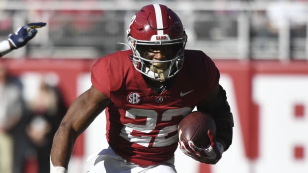 Alabama Crimson Tide running back Justice Haynes on a rushing attempt during a college football game in the SEC.