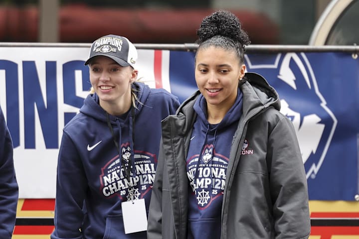 UConn's Paige Bueckers and Azzi Fudd walk onto the stage during the Final Four Champions victory parade 