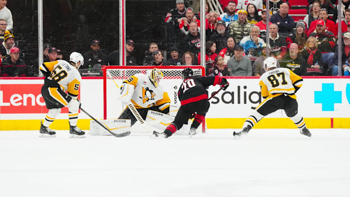Jan 5, 2025; Raleigh, North Carolina, USA;  Carolina Hurricanes center Sebastian Aho (20) scores the game winning goal in the overt time past Pittsburgh Penguins goaltender Alex Nedeljkovic (39) at Lenovo Center. Mandatory Credit: James Guillory-Imagn Images