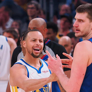 Golden State Warriors guard Stephen Curry (30) and Denver Nuggets center Nikola Jokic (15) in a confrontation as a time out is called during the first quarter of game two of the first round for the 2022 NBA playoffs at Chase Center. Mandatory Credit: Kelley L Cox-Imagn Images