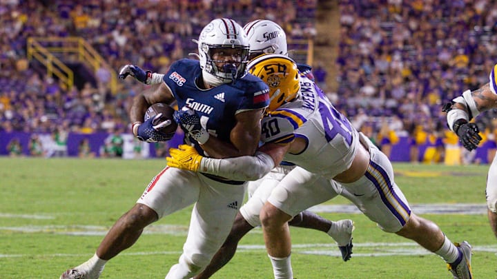 Sep 28, 2024; Baton Rouge, Louisiana, USA;  South Alabama Jaguars running back Fluff Bothwell (24) is tackled by LSU Tigers linebacker Whit Weeks (40) during the second half at Tiger Stadium. Mandatory Credit: Stephen Lew-Imagn Images