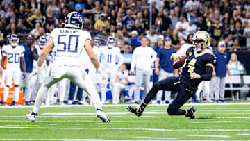 Sep 10, 2023; New Orleans, Louisiana, USA;  New Orleans Saints quarterback Derek Carr (4) slides to avoid the tackle of Tennessee Titans linebacker Jack Gibbens (50) during the first half at the Caesars Superdome. Mandatory Credit: Stephen Lew-Imagn Images
