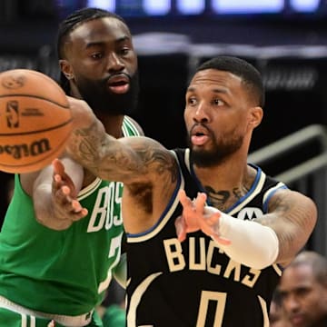 Milwaukee Bucks guard Damian Lillard (0) gets a pass away from Boston Celtics forward Jaylen Brown (7) in the third quarter at Fiserv Forum.