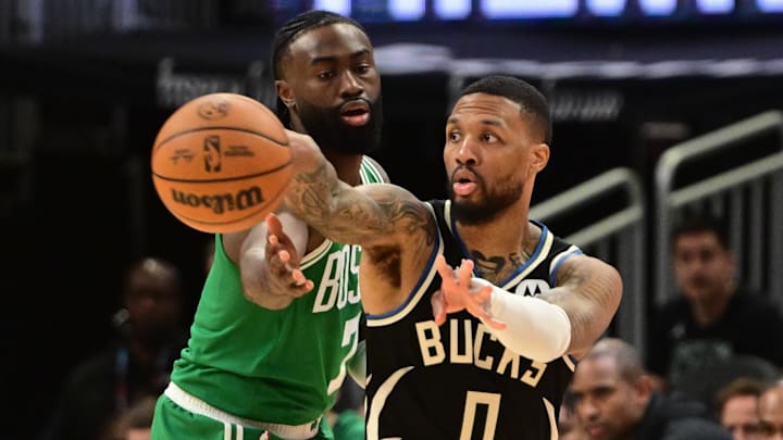 Milwaukee Bucks guard Damian Lillard (0) gets a pass away from Boston Celtics forward Jaylen Brown (7) in the third quarter at Fiserv Forum.