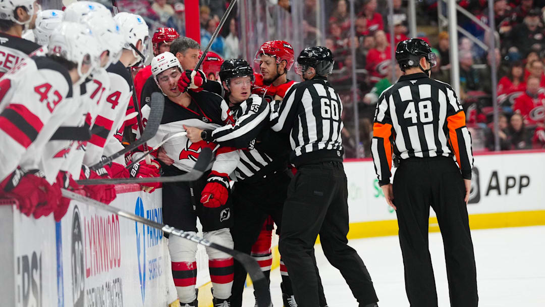 Dec 28, 2024; Raleigh, North Carolina, USA;  Carolina Hurricanes center Jesperi Kotkaniemi (82) fights New Jersey Devils right wing Timo Meier (28) after his hit on 
 center Martin Necas (88) (not shown) during the third period at Lenovo Center. Mandatory Credit: James Guillory-Imagn Images