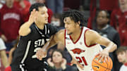 Mar 8, 2025; Fayetteville, Arkansas, USA; Arkansas Razorbacks guard D.J. Wagner (21) drives against Mississippi State Bulldogs forward RJ Melendez (22) during the second half at Bud Walton Arena. Arkansas won 93-92. Mandatory Credit: Nelson Chenault-Imagn Images
