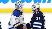 St. Louis Blues goaltender Jordan Binnington and Winnipeg Jets goaltender Connor Hellebuyck shake hands.