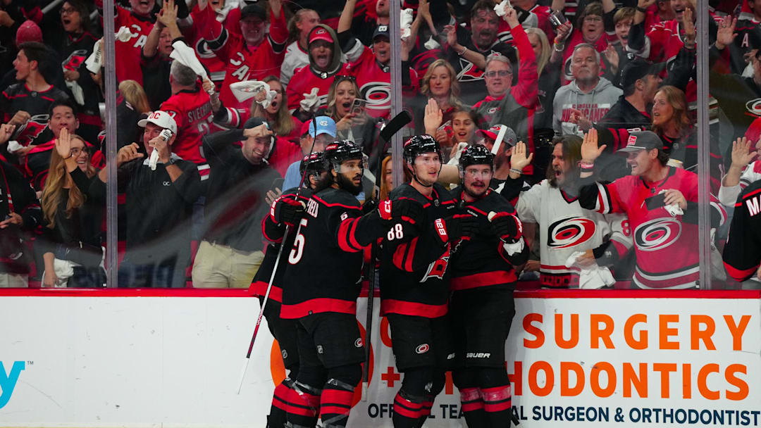 May 16, 2024; Raleigh, North Carolina, USA; Carolina Hurricanes center Martin Necas (88) celebrates his goal with defenseman Dmitry Orlov (7) and defenseman Jalen Chatfield (5) against the New York Rangers during the first period in game six of the second round of the 2024 Stanley Cup Playoffs at PNC Arena. Mandatory Credit: James Guillory-Imagn Images