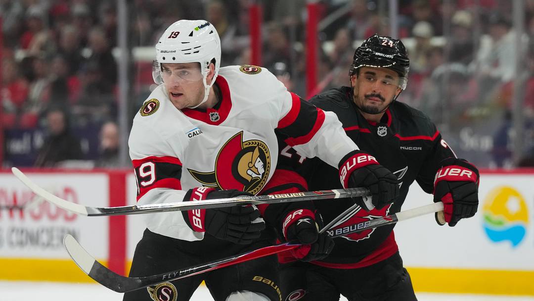 Apr 20, 2026; Raleigh, North Carolina, USA; Carolina Hurricanes center Seth Jarvis (24) and Ottawa Senators right wing Drake Batherson (19) battle in the first overtime period in game two of the first round of the 2026 Stanley Cup Playoffs at Lenovo Center. Mandatory Credit: James Guillory-Imagn Images