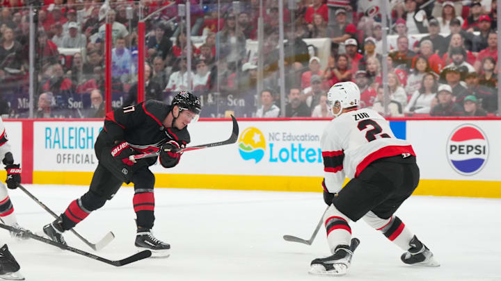 Apr 18, 2026; Raleigh, North Carolina, USA; Carolina Hurricanes right wing Andrei Svechnikov (37) gets the shot past Ottawa Senators defenseman Artem Zub (2) during the first period in game one of the first round of the 2026 Stanley Cup Playoffs at Lenovo Center. Mandatory Credit: James Guillory-Imagn Images