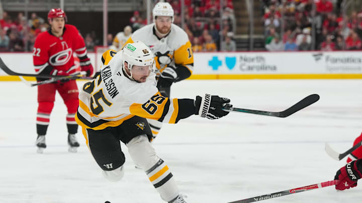 Mar 18, 2026; Raleigh, North Carolina, USA;  Pittsburgh Penguins defenseman Erik Karlsson (65) takes a shot against the Carolina Hurricanes during the second period at Lenovo Center. Mandatory Credit: James Guillory-Imagn Images