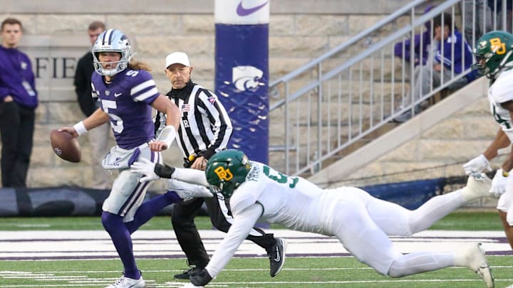 Nov 11, 2023; Manhattan, Kansas, USA; Kansas State Wildcats quarterback Avery Johnson runs away from Baylor Bears defensive lineman TJ Franklin (9) during the fourth quarter at Bill Snyder Family Football Stadium. Mandatory Credit: Scott Sewell-Imagn Images