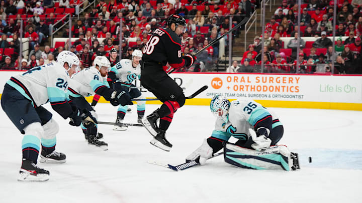 Dec 3, 2024; Raleigh, North Carolina, USA;  Carolina Hurricanes center Martin Necas (88) scores a goal past Seattle Kraken goaltender Joey Daccord (35) during the third period at Lenovo Center. Mandatory Credit: James Guillory-Imagn Images