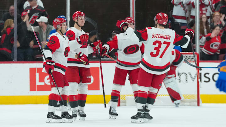 Nov 8, 2025; Raleigh, North Carolina, USA;  Carolina Hurricanes defenseman Charles Alexis Legault (62) celebrates his first NHL goal (empty net) with center Sebastian Aho (20) defenseman Mike Reilly (6) and right wing Andrei Svechnikov (37) against the Buffalo Sabres during the third period at Lenovo Center. Mandatory Credit: James Guillory-Imagn Images