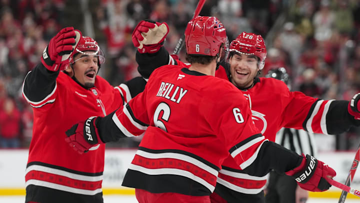 Oct 30, 2025; Raleigh, North Carolina, USA;  Carolina Hurricanes defenseman Mike Reilly (6) celebrates his goal witb center Seth Jarvis (24) and  defenseman Sean Walker (26) against the New York Islanders during the first period at Lenovo Center. Mandatory Credit: James Guillory-Imagn Images