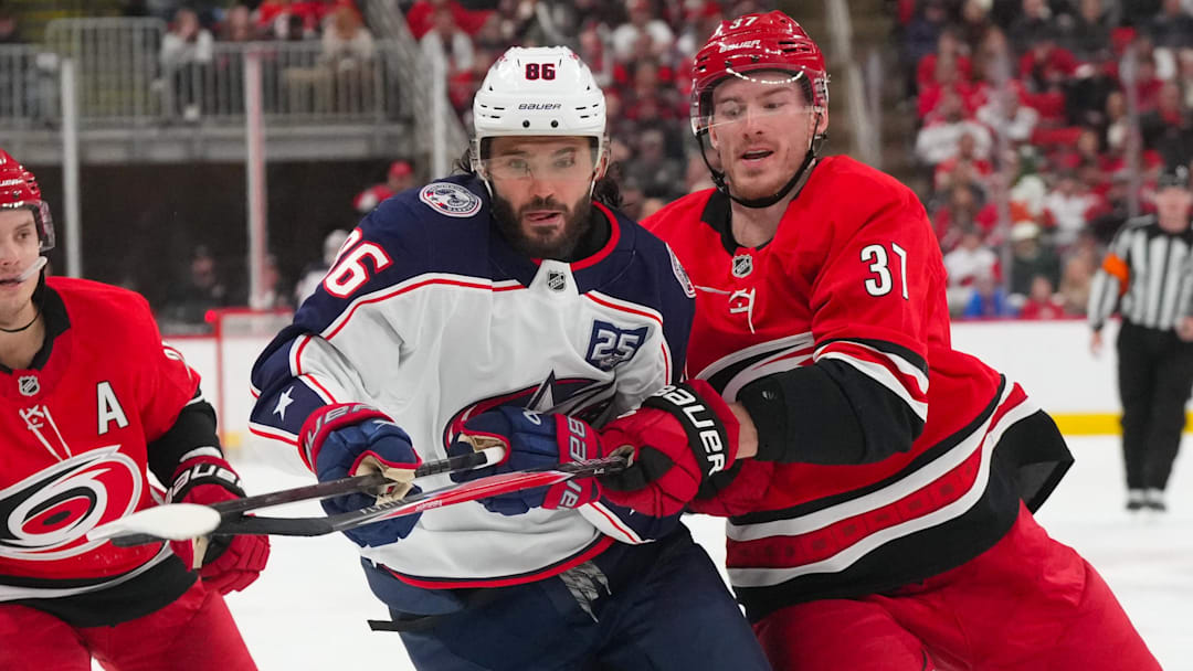Dec 9, 2025; Raleigh, North Carolina, USA;  Carolina Hurricanes right wing Andrei Svechnikov (37) and Columbus Blue Jackets right wing Kirill Marchenko (86) watch the play during the second period at Lenovo Center. Mandatory Credit: James Guillory-Imagn Images
