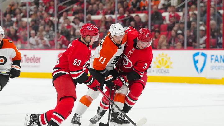 Dec 14, 2025; Raleigh, North Carolina, USA; Carolina Hurricanes right wing Jackson Blake (53) and right wing Andrei Svechnikov (37) battle Philadelphia Flyers right wing Travis Konecny (11) for the puck in the overtime at Lenovo Center. Mandatory Credit: James Guillory-Imagn Images